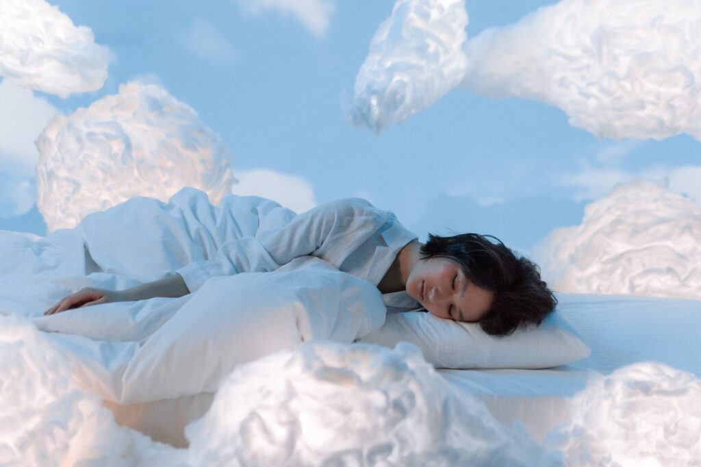 photo of a woman sleeping near fluffy clouds