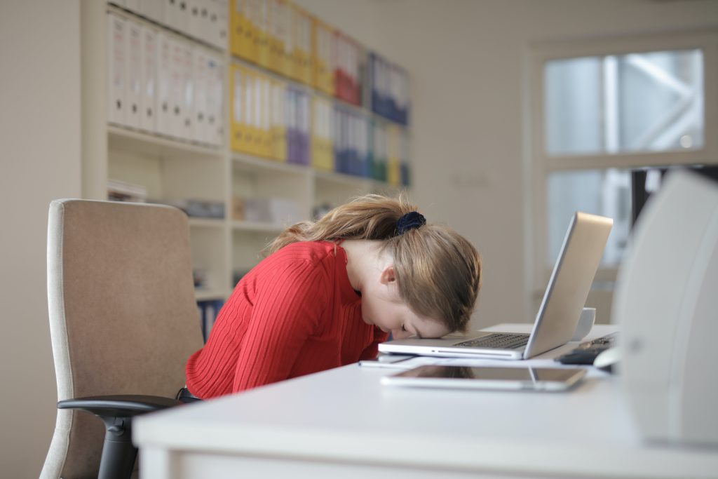 woman sleeping on laptop after working night shift