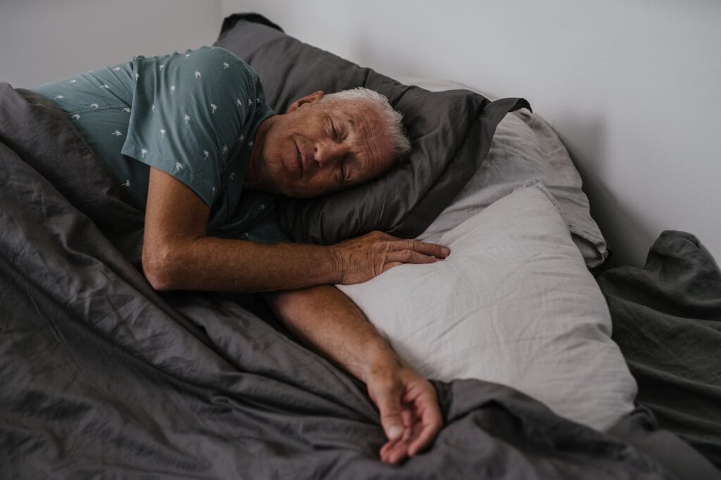 older man sleeping in man with high risk of sleep apnea due to age