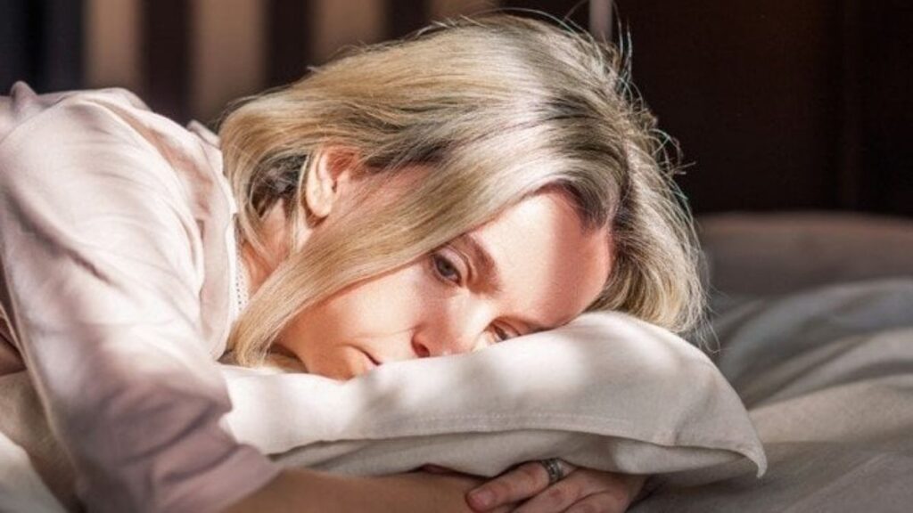 woman laying on a bed stressed out