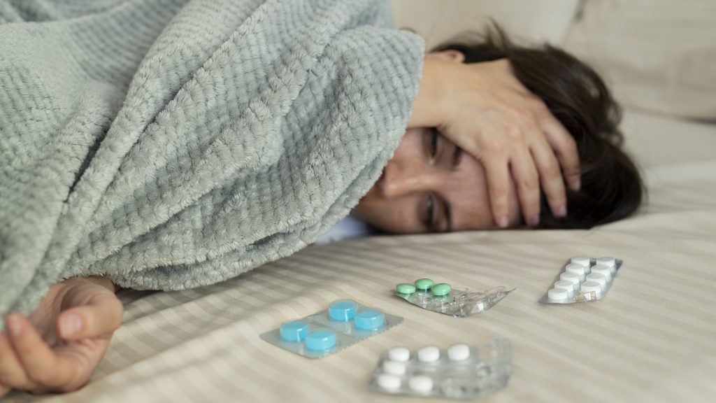 a woman with insomnia and sleeping pills on the bed