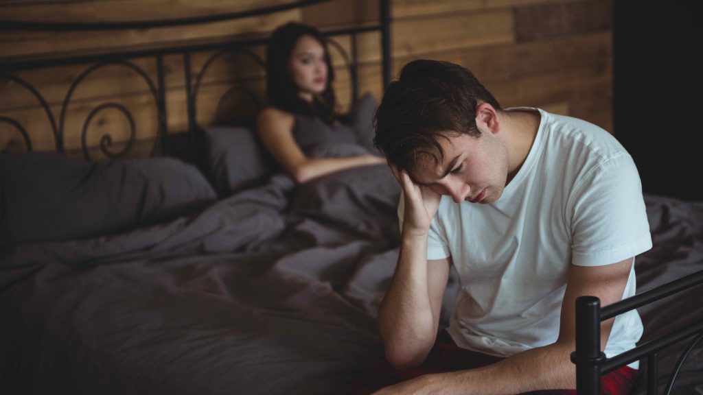 upset couple ignoring each other during a bedtime conflict