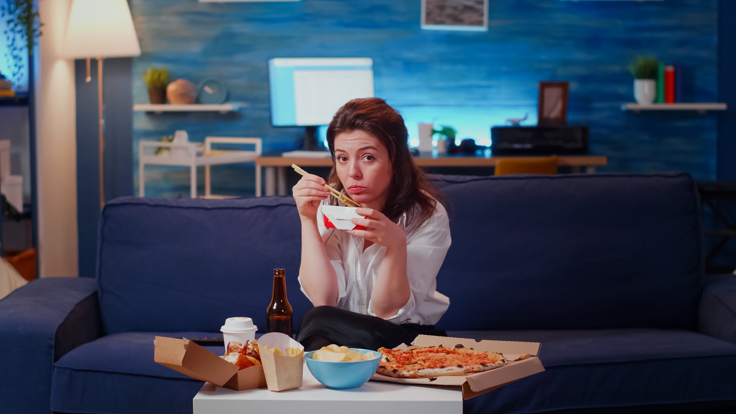 young woman eating chinese food with chopsticks before sleep