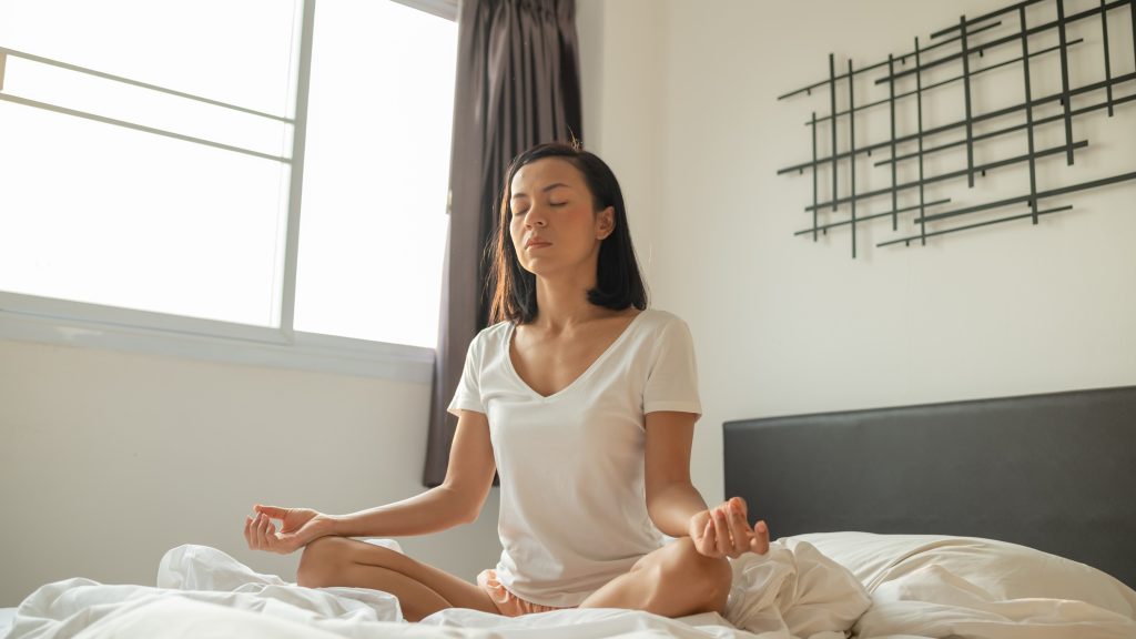 woman practicing meditation and breathing exercises for insomnia relief