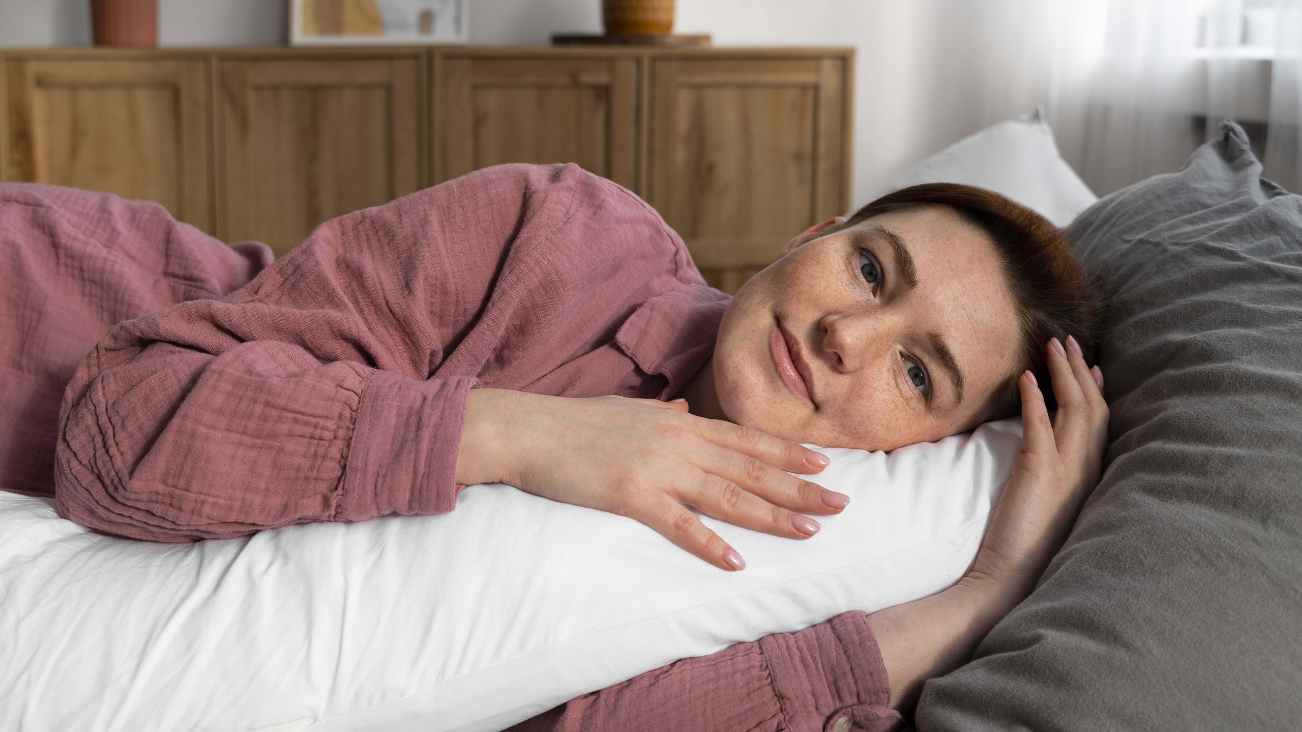woman in pajamas resting comfortably on a pillow illustrating gentle strategies to improve sleep quality during menopause