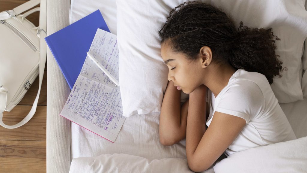 young girl sleeping peacefully in bed illustrating a healthy back to school sleep schedule transition
